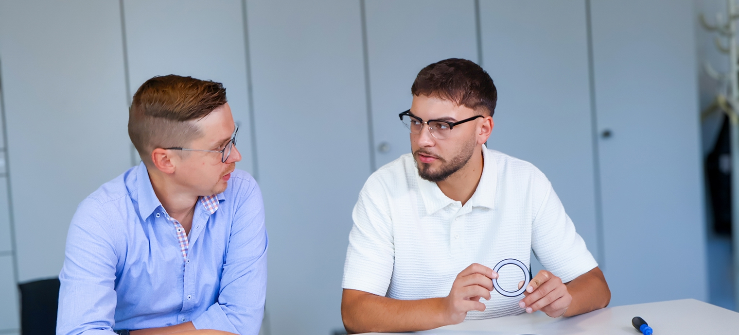 Zwei Kollegen diskutieren in einem modernen Büro.